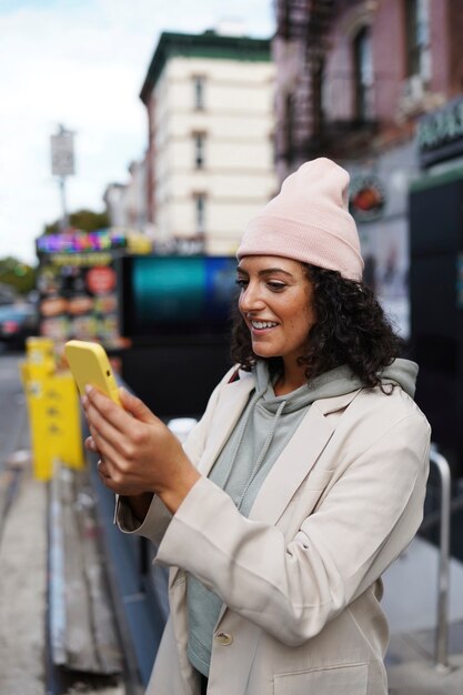 Giovane donna alla moda in città che utilizza smartphone per l'esplorazione