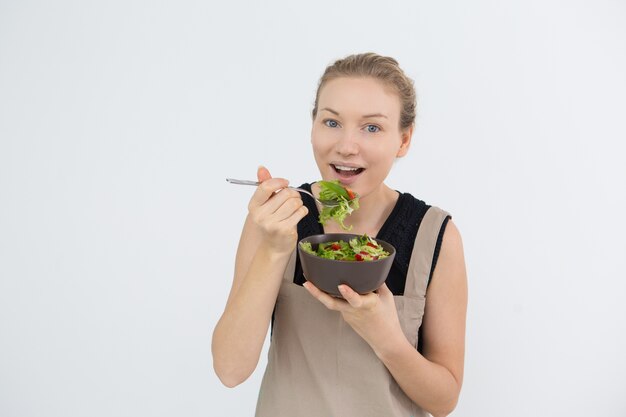 Giovane donna allegra che mangia cibo sano