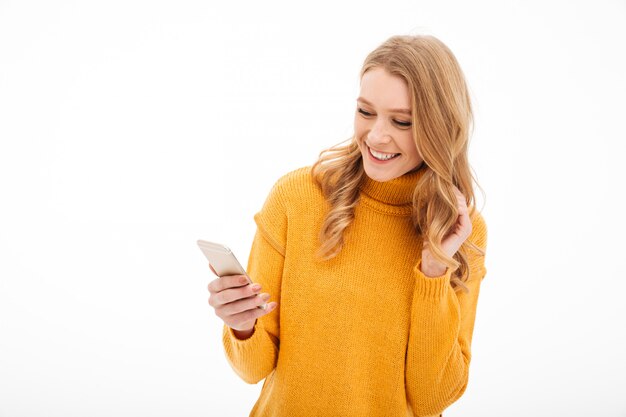 Giovane donna allegra che per mezzo del telefono cellulare.