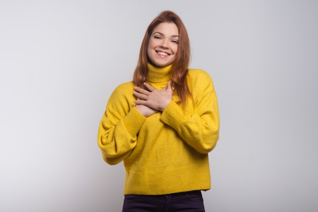 Giovane donna allegra con le mani sul petto