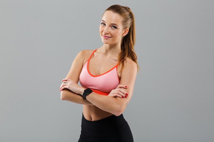 Foto gratuito giovane donna allegra di sport con le braccia attraversate.