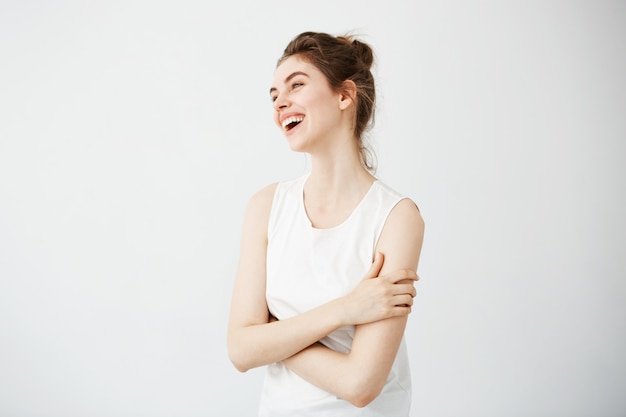 Giovane donna allegra felice con la risata sorridente del panino. Braccia incrociate.