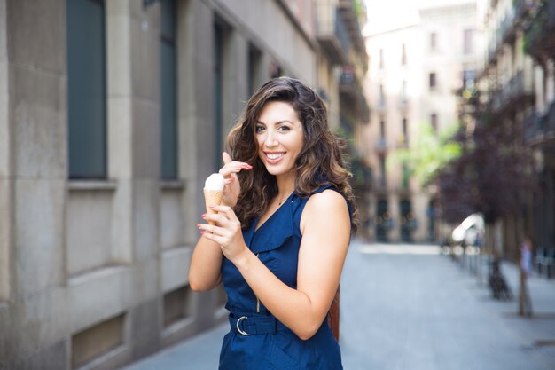 Giovane donna allegra mangiare il gelato all&#39;aperto