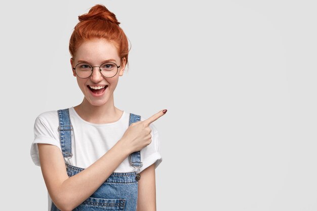 Giovane donna allo zenzero che indossa una tuta in denim