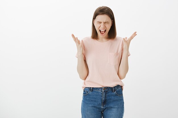 Giovane donna angosciata e stufo che si sente stressato urlando sconvolto