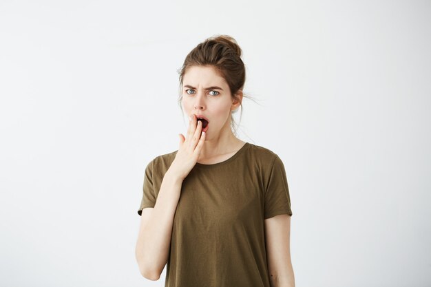 Giovane donna annoiata stanca che sbadiglia.