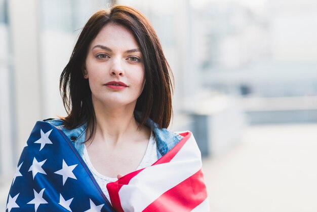 Giovane donna arrotolando in bandiera americana