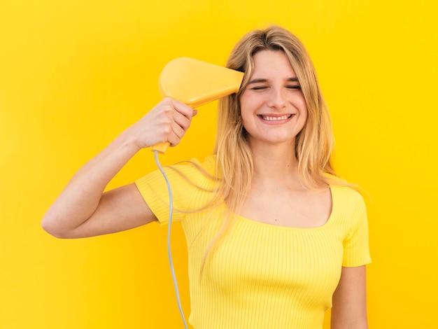 Giovane donna asciugando i capelli