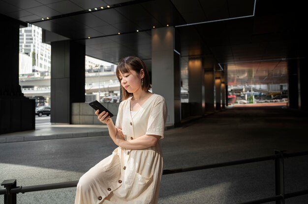 Giovane donna asiatica che controlla il suo telefono