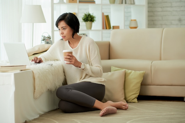 Giovane donna asiatica che gode delle comodità domestiche