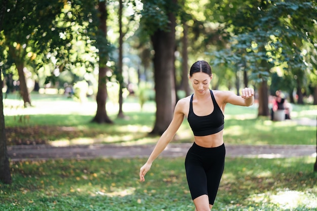 Giovane donna atletica che fa yoga nel parco al mattino