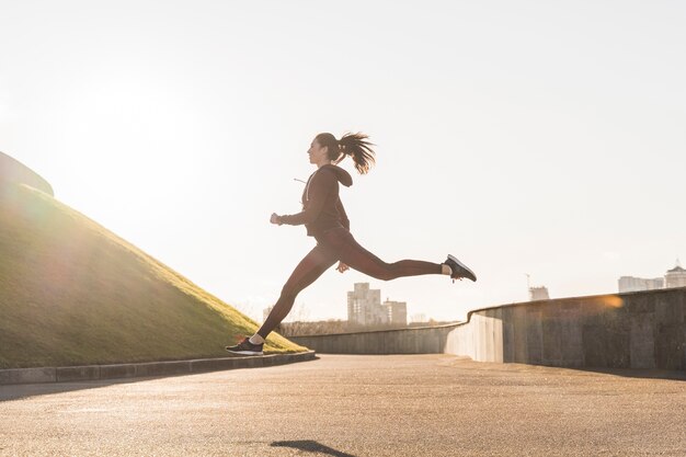 Giovane donna attiva che corre all'aperto