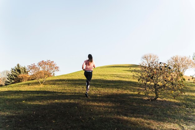 Giovane donna attiva che funziona nel parco