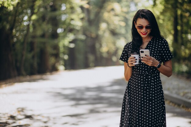 Giovane donna attraente che parla al telefono nel parco