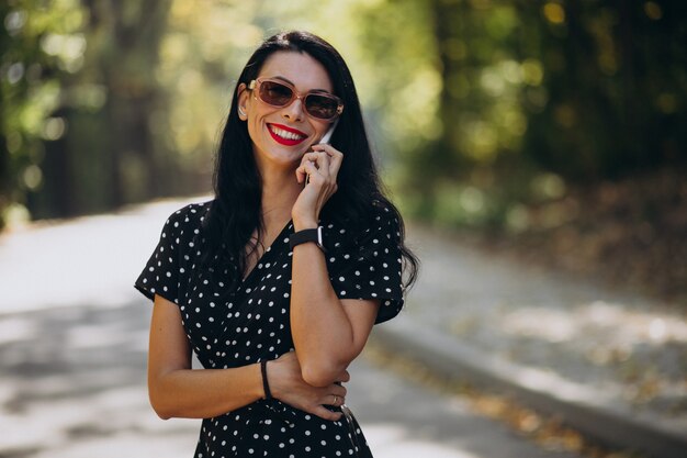 Giovane donna attraente che parla al telefono nel parco