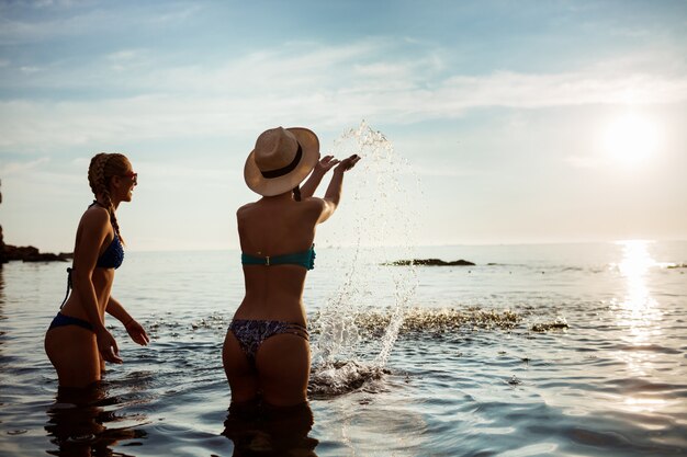 Giovane donna attraente che si rallegra, nuota nel mare