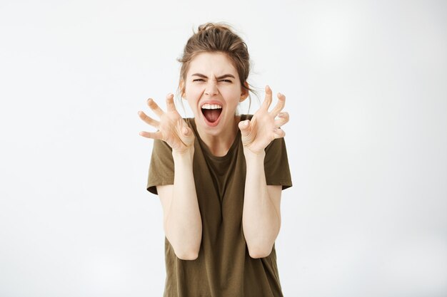 Giovane donna attraente emotiva che gesturing gridare.