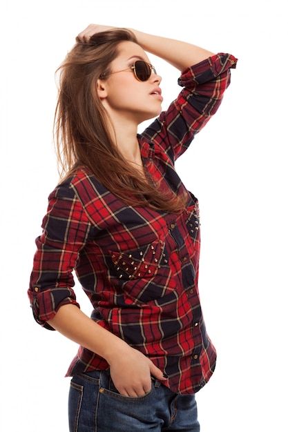 Giovane donna attraente in camicia e occhiali da sole