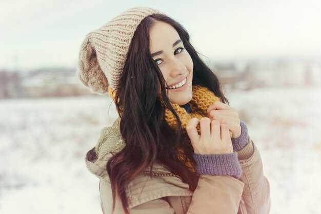 Giovane donna attraente nell'orario invernale all'aperto