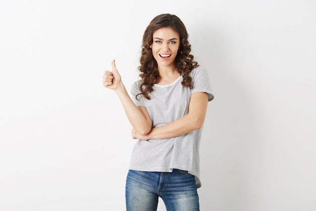 Giovane donna attraente vestita in jeans e t-shirt abbigliamento casual che mostra gesto positivo, sorridente, felice, stile hipster, isolato, ricci, pollice in alto