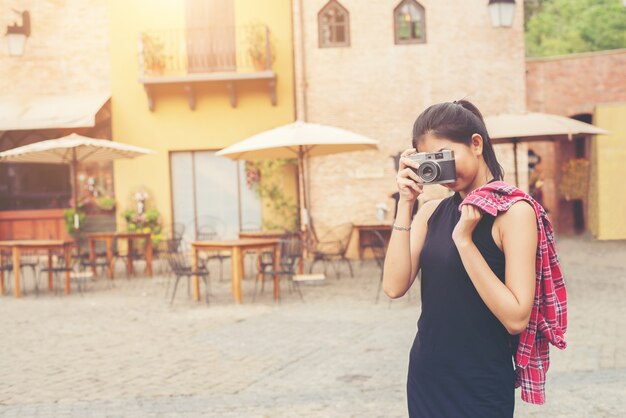 Giovane donna bellissima con fotocamera retrò, stile retrò vintage Come