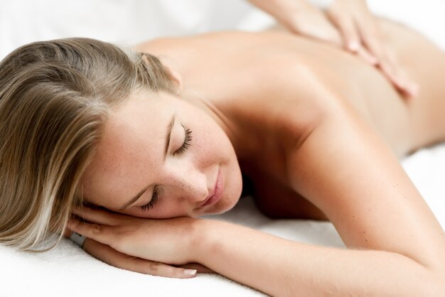 Giovane donna bionda che ha massaggio nel salone spa