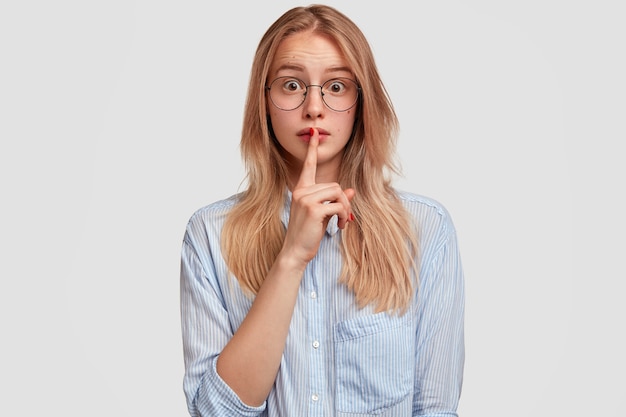 Giovane donna bionda che indossa la camicia blu