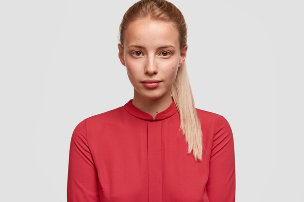Giovane donna bionda che indossa una camicia rossa