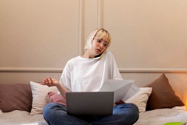 Giovane donna bionda che lavora da casa sul suo laptop