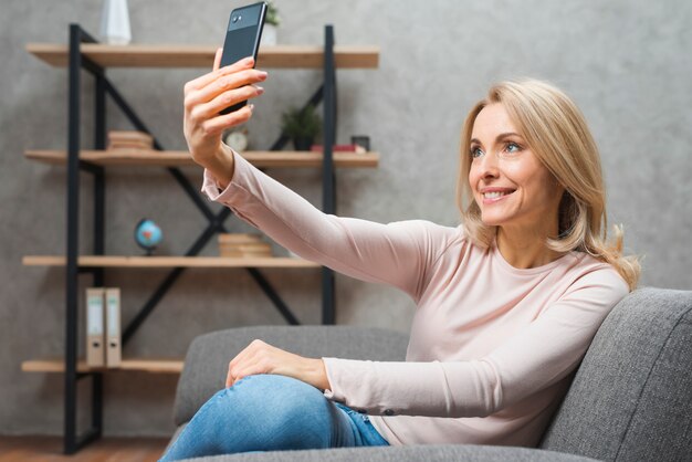 Giovane donna bionda che prende selfie dal telefono cellulare