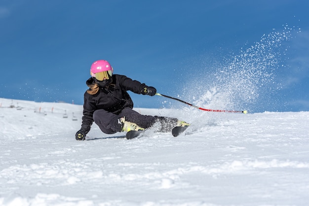 Giovane donna bionda che scia in una giornata di sole
