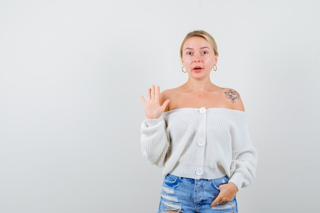 Giovane donna bionda con un maglione bianco