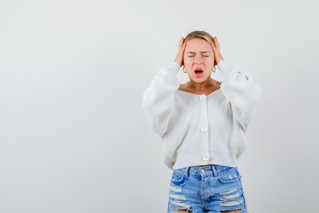 Giovane donna bionda con un maglione bianco