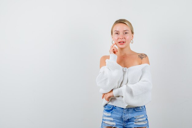 Giovane donna bionda con un maglione bianco