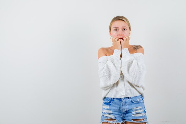 Giovane donna bionda con un maglione bianco