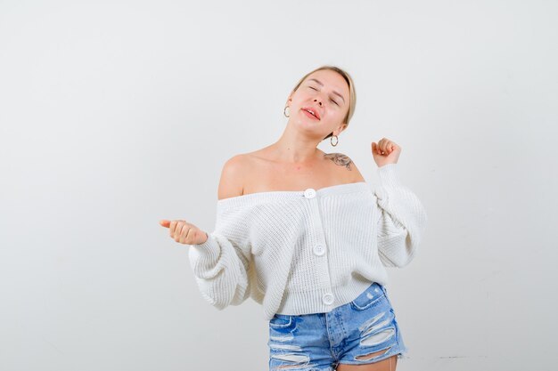 Giovane donna bionda con un maglione bianco