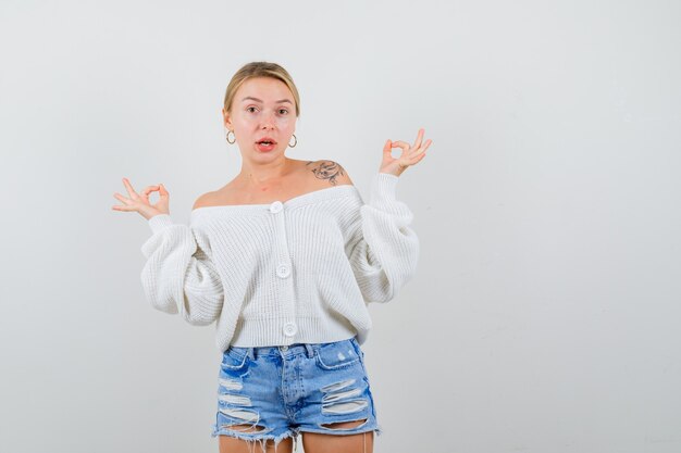 Giovane donna bionda con un maglione bianco