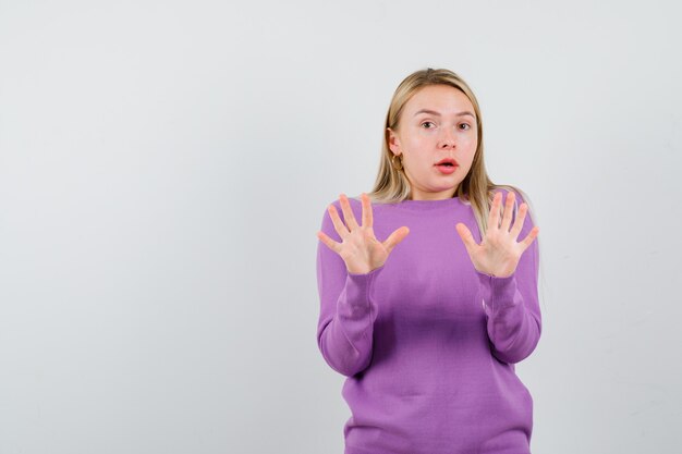 Giovane donna bionda con un maglione viola