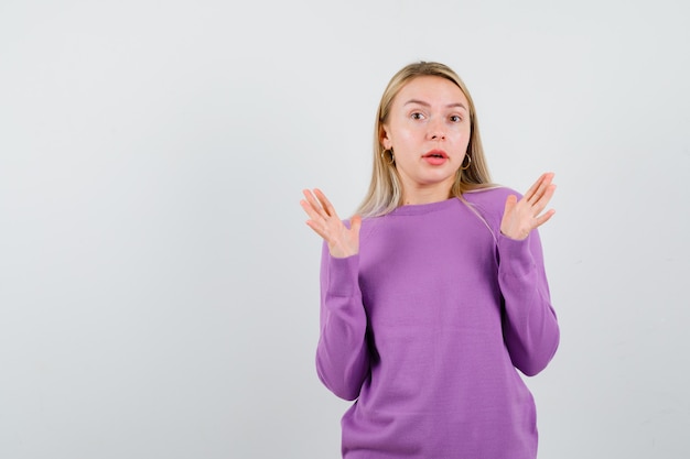 Giovane donna bionda con un maglione viola