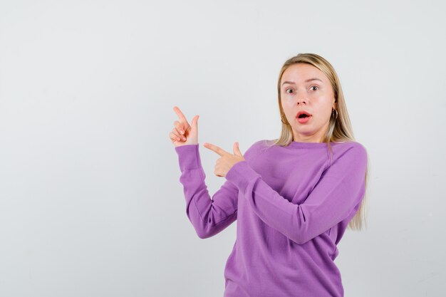 Giovane donna bionda con un maglione viola