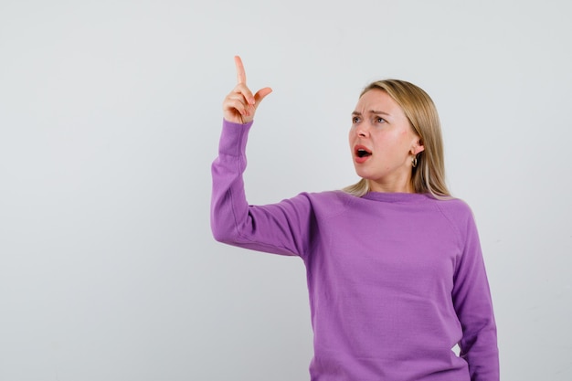 Giovane donna bionda con un maglione viola