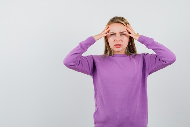 Giovane donna bionda con un maglione viola