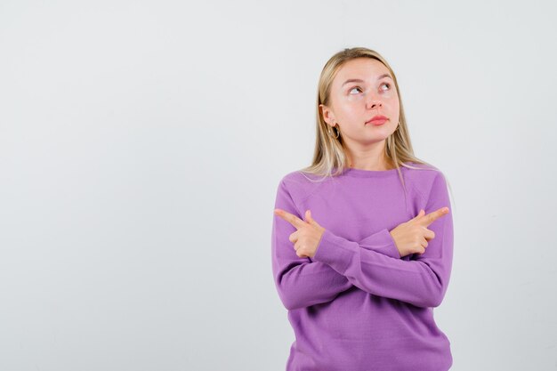 Giovane donna bionda con un maglione viola