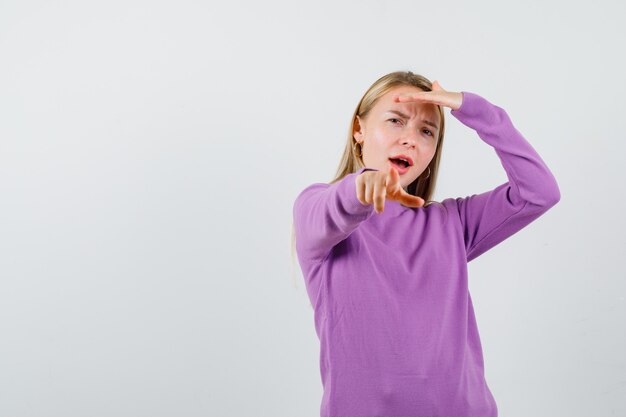 Giovane donna bionda con un maglione viola