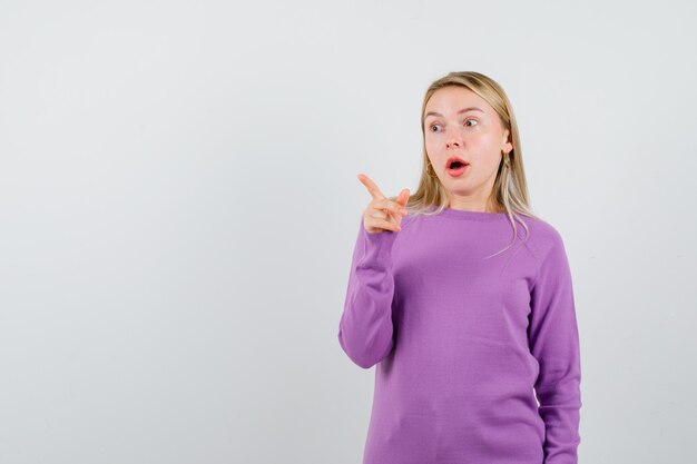 Giovane donna bionda con un maglione viola