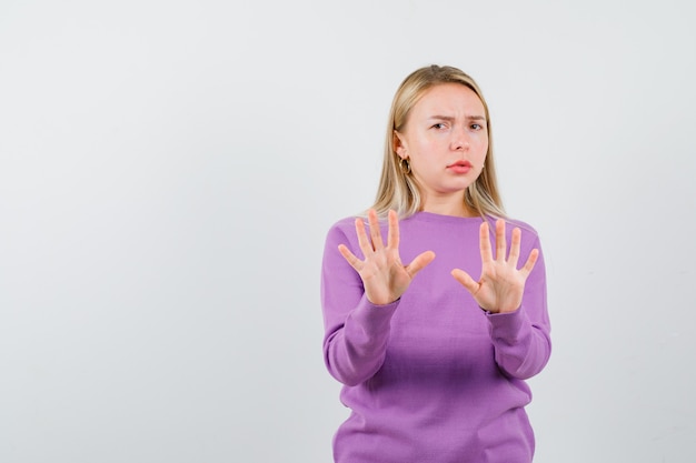 Giovane donna bionda con un maglione viola