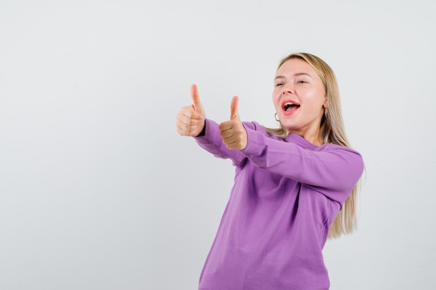 Giovane donna bionda con un maglione viola