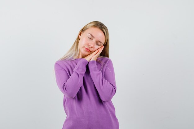 Giovane donna bionda con un maglione viola