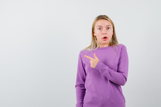 Giovane donna bionda con un maglione viola