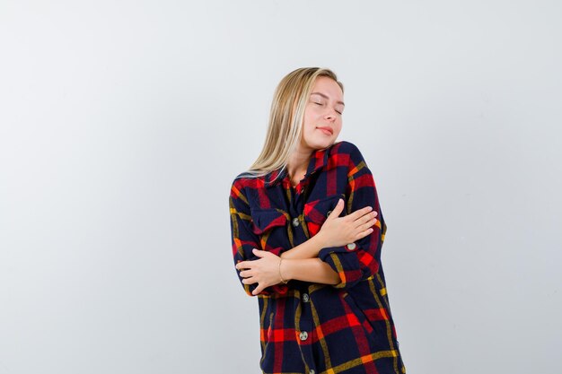 Giovane donna bionda con una camicia a scacchi